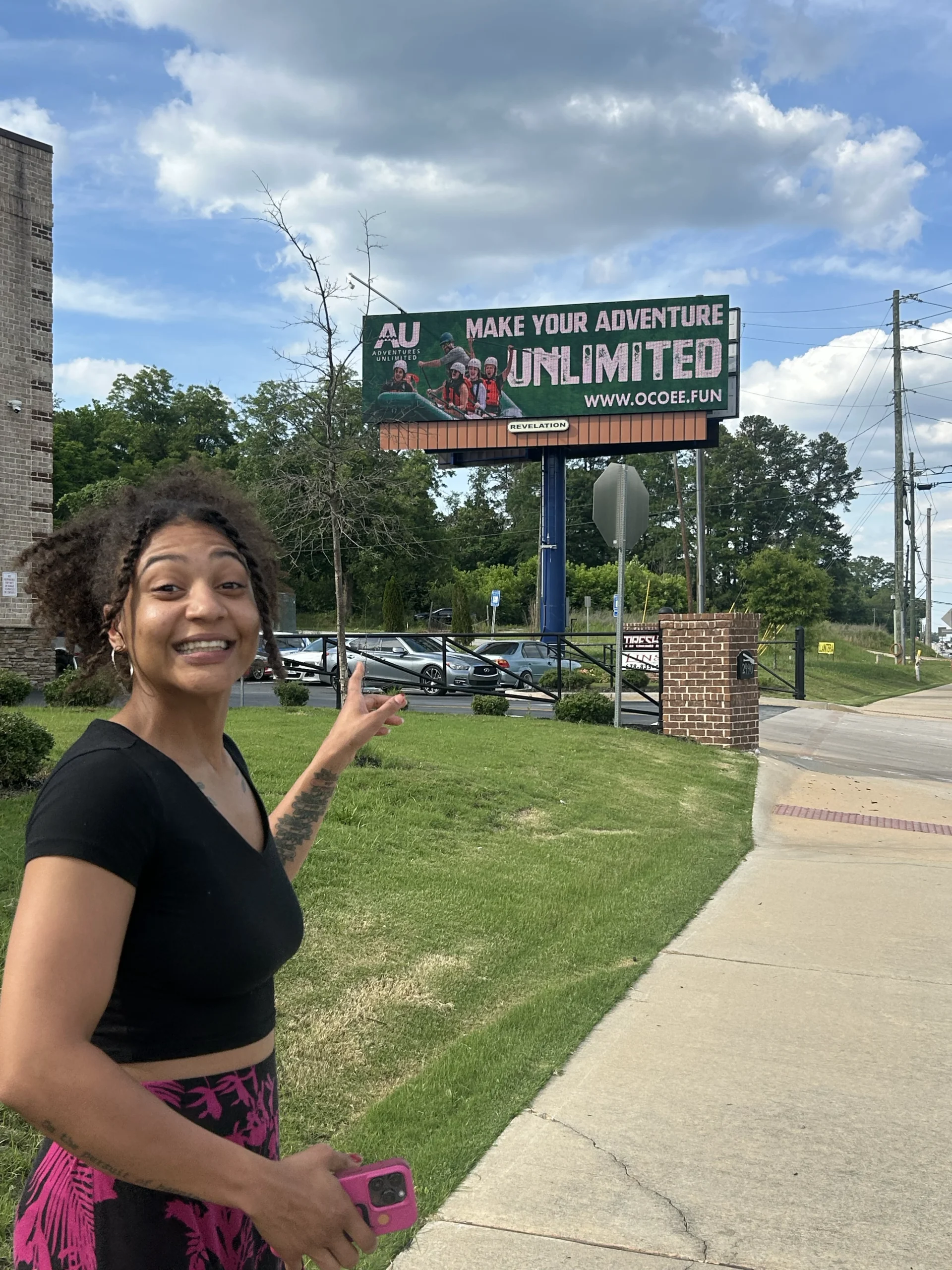 a picture of a girl standing in front a billboard smiling